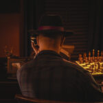 a man dressed in mafia-style clothes calling on a telephone